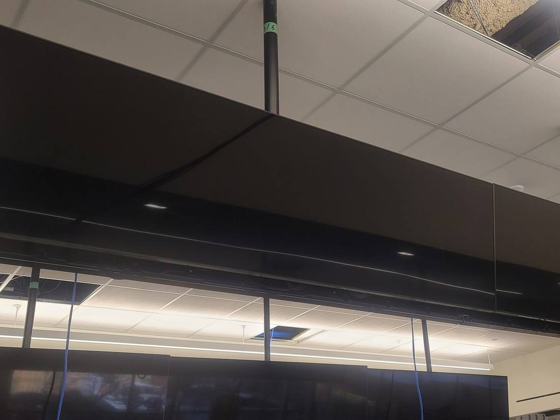 Finished ceiling-mounted ribbon display in an office ceiling