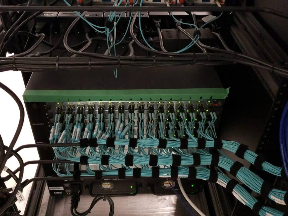 Fiber patch panel with labeled teal cable terminations