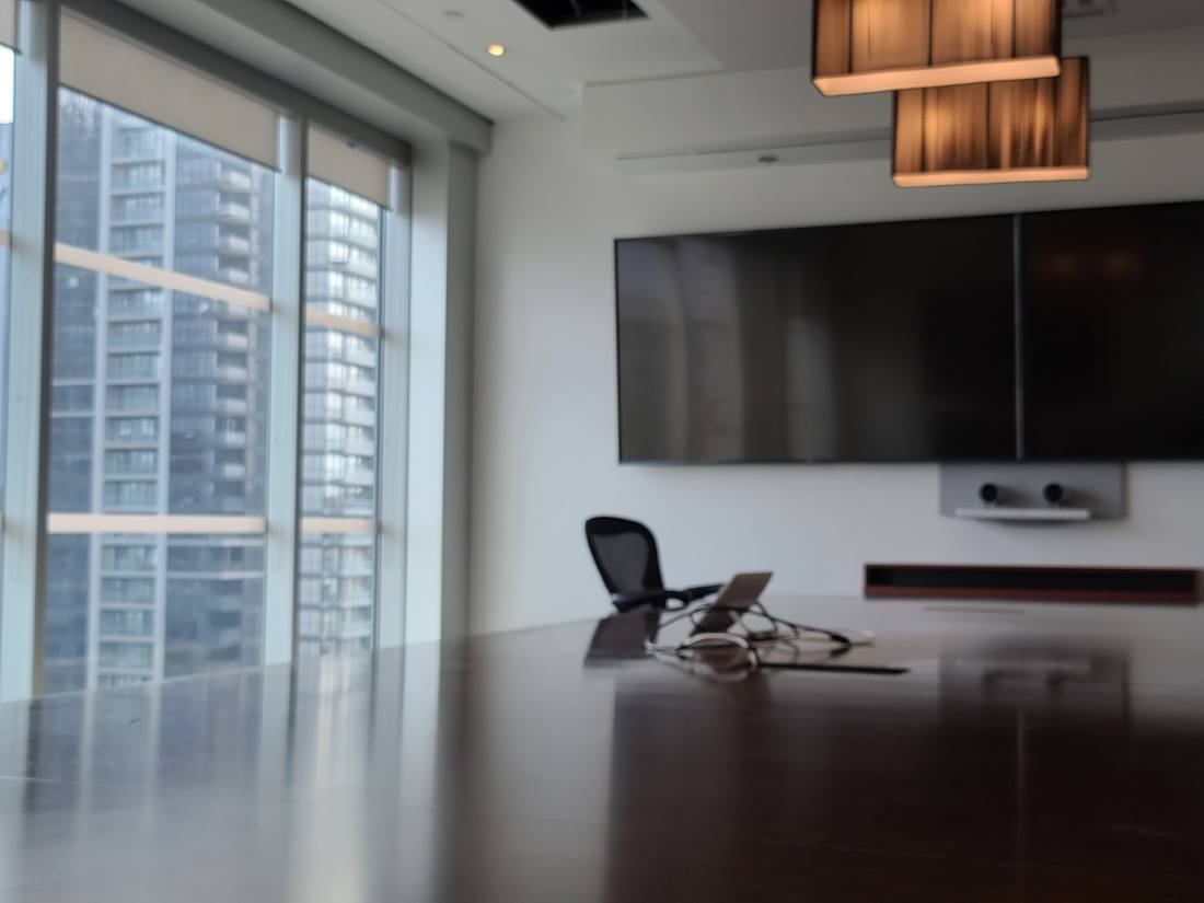 Executive boardroom with city skyline view and dual displays