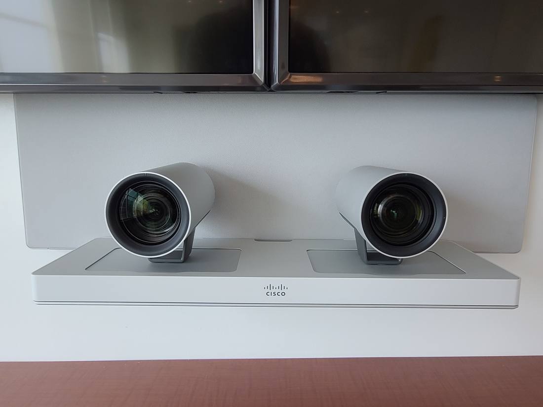 Dual Cisco PTZ conferencing cameras mounted beneath twin displays