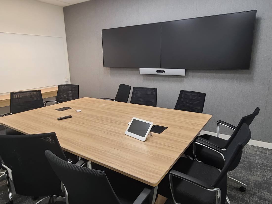 Eight-seat boardroom with dual displays and tabletop touch controller