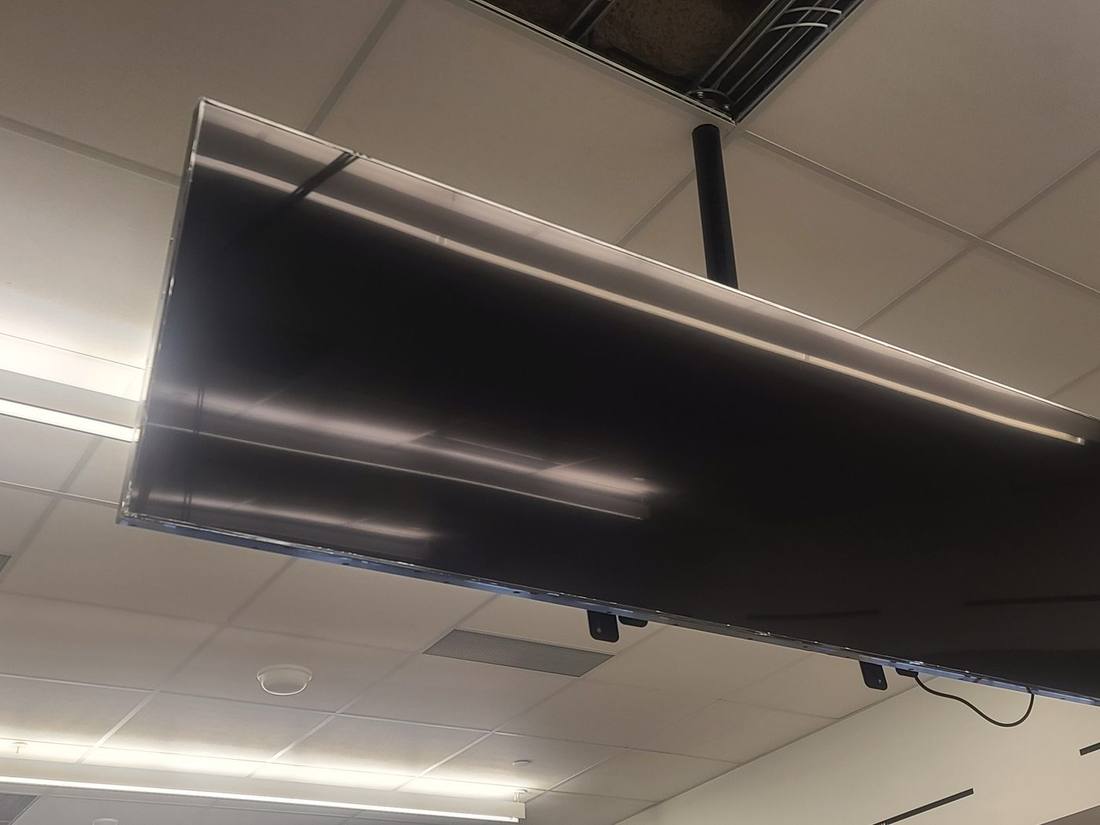 Ceiling-mounted ribbon display against the building's structural grid