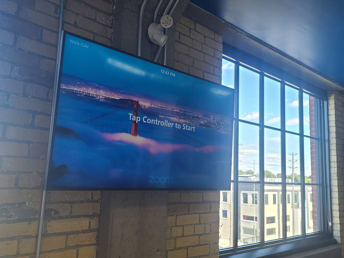 Zoom Room display mounted on an exposed brick wall