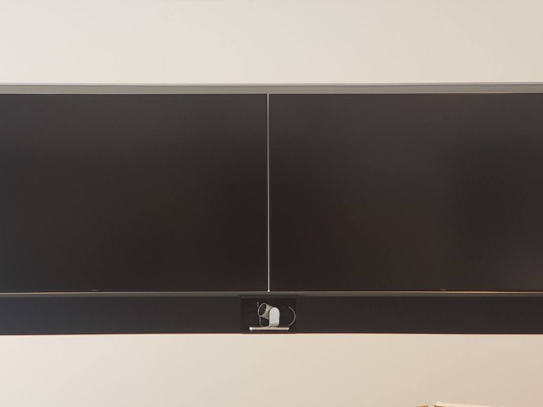 Dual-display video conferencing suite with centered camera bar