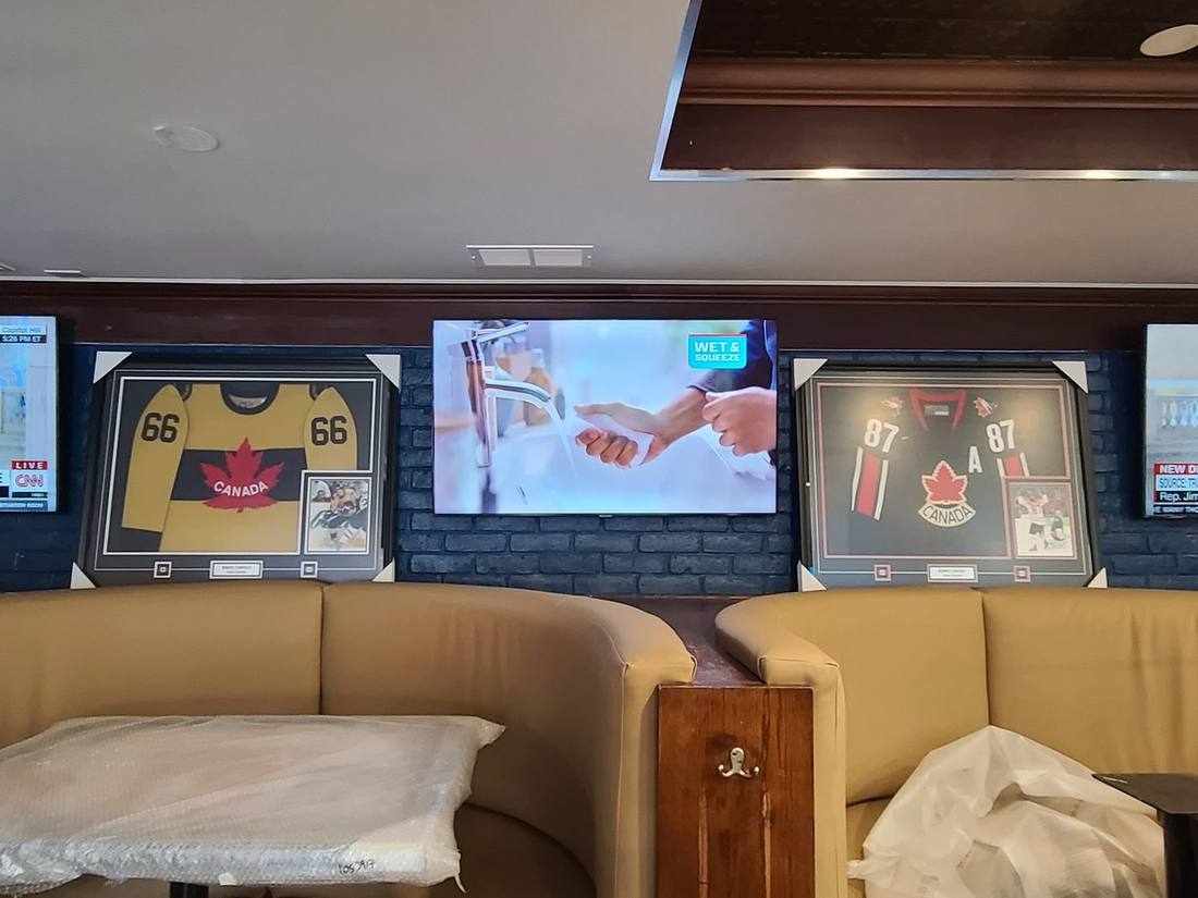 Display mounted between framed hockey jerseys on a memorabilia wall