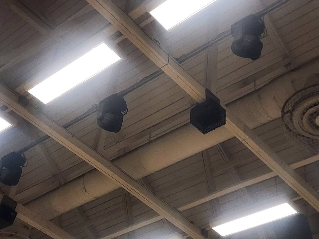 Exposed ceiling rafters with speakers and moving-head fixtures