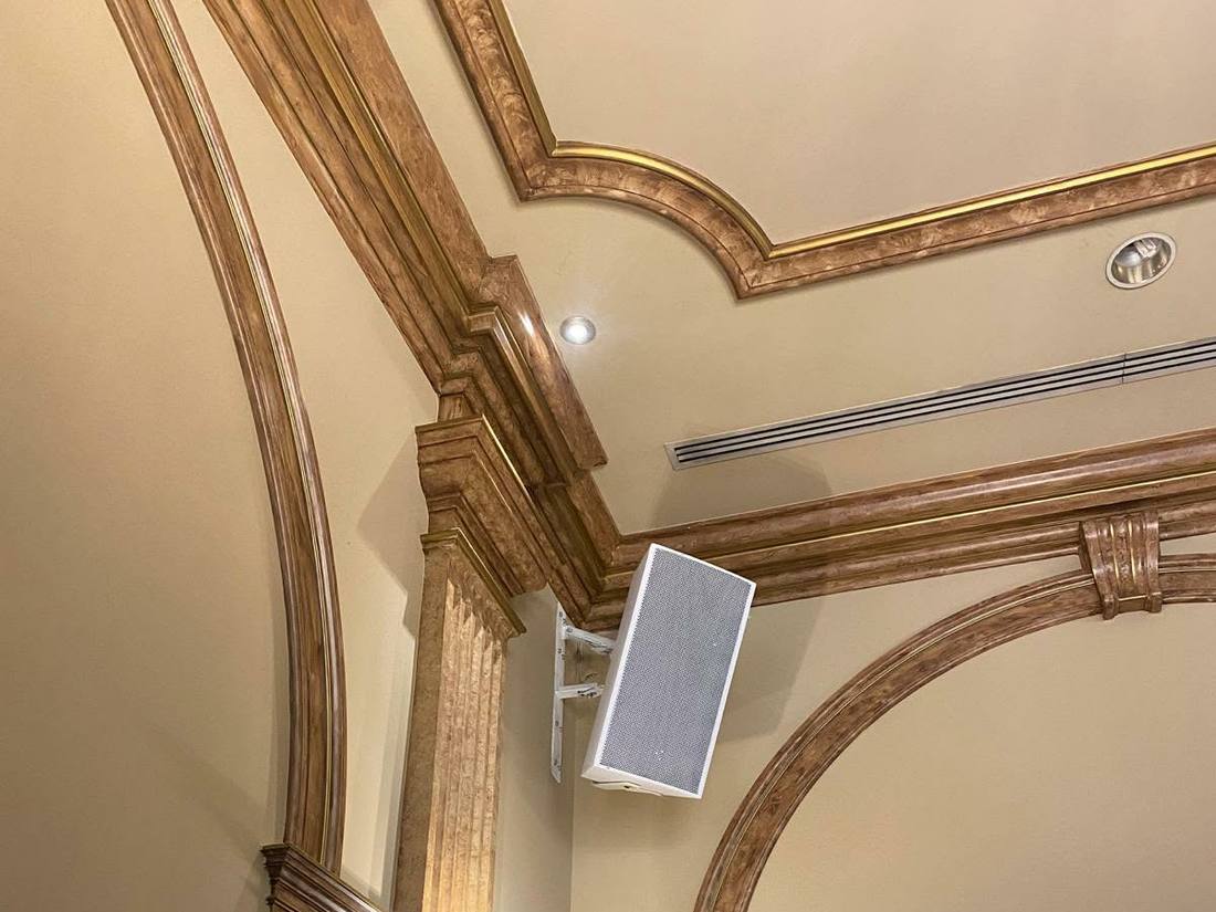 Speaker mounted in an ornate gilded ceiling corner