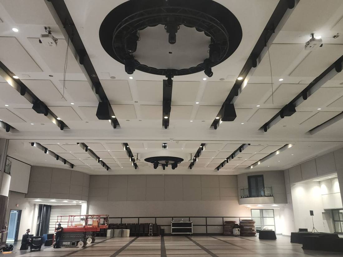 Large ballroom under construction with dropped panel ceiling and truss runs