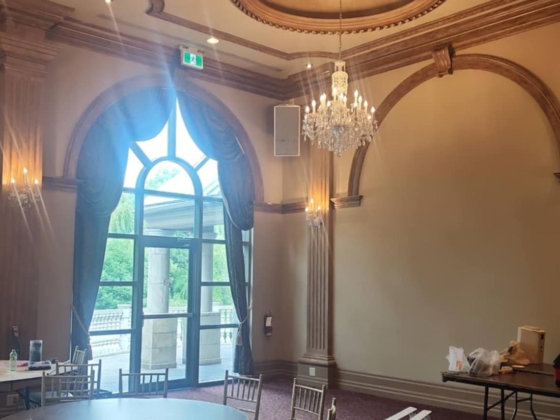 Ballroom bay with arched window, chandelier and round tables