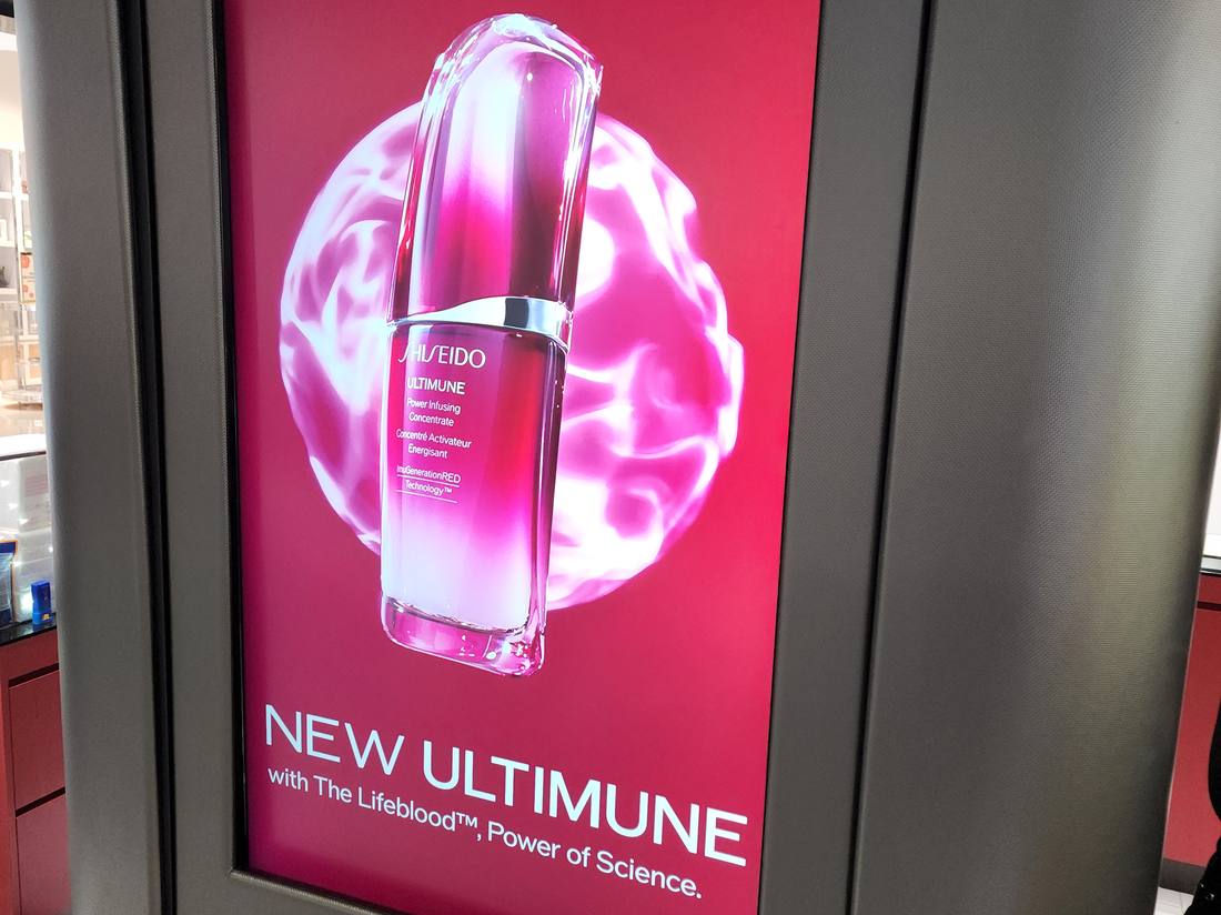 Digital kiosk display advertising a skincare product in a medical building concourse