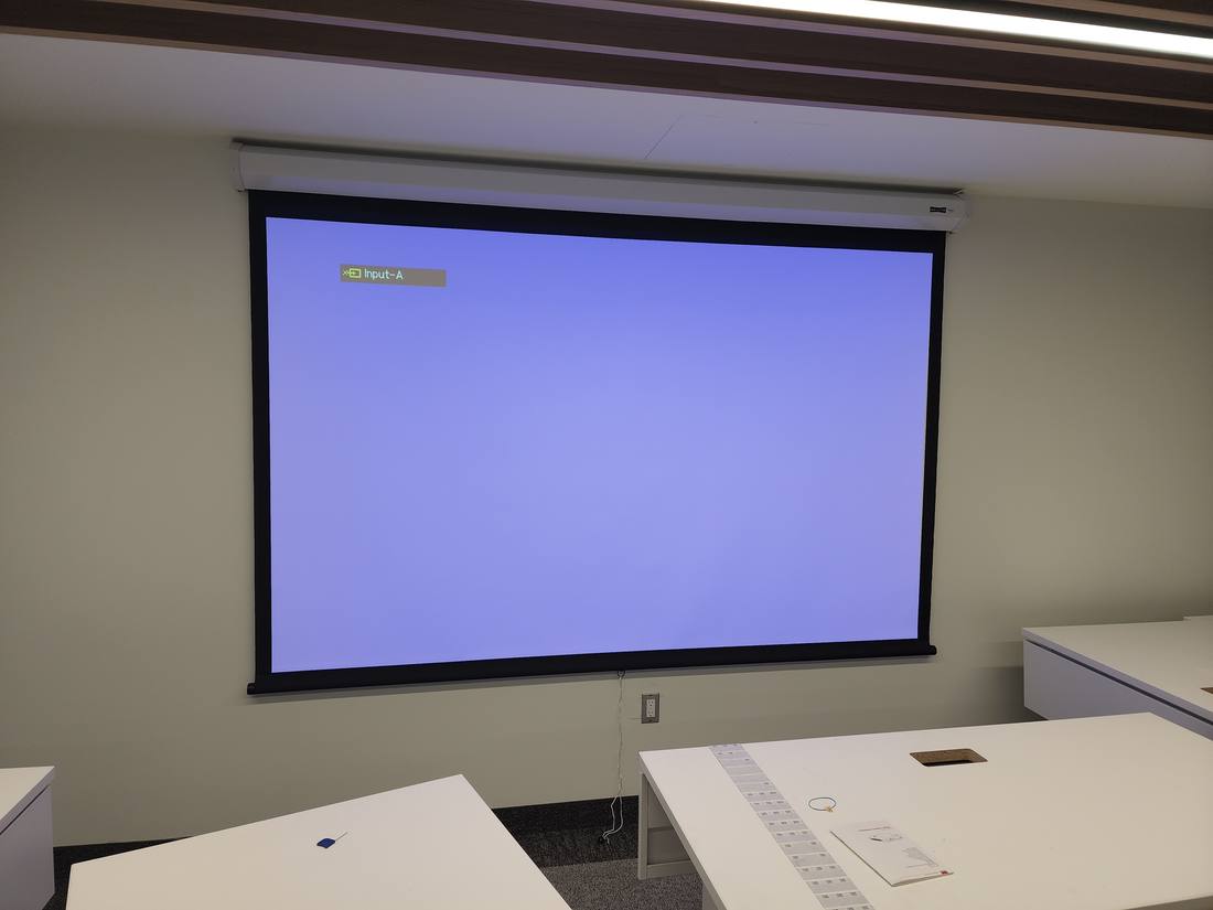 Pull-down projector screen showing an input-standby signal
