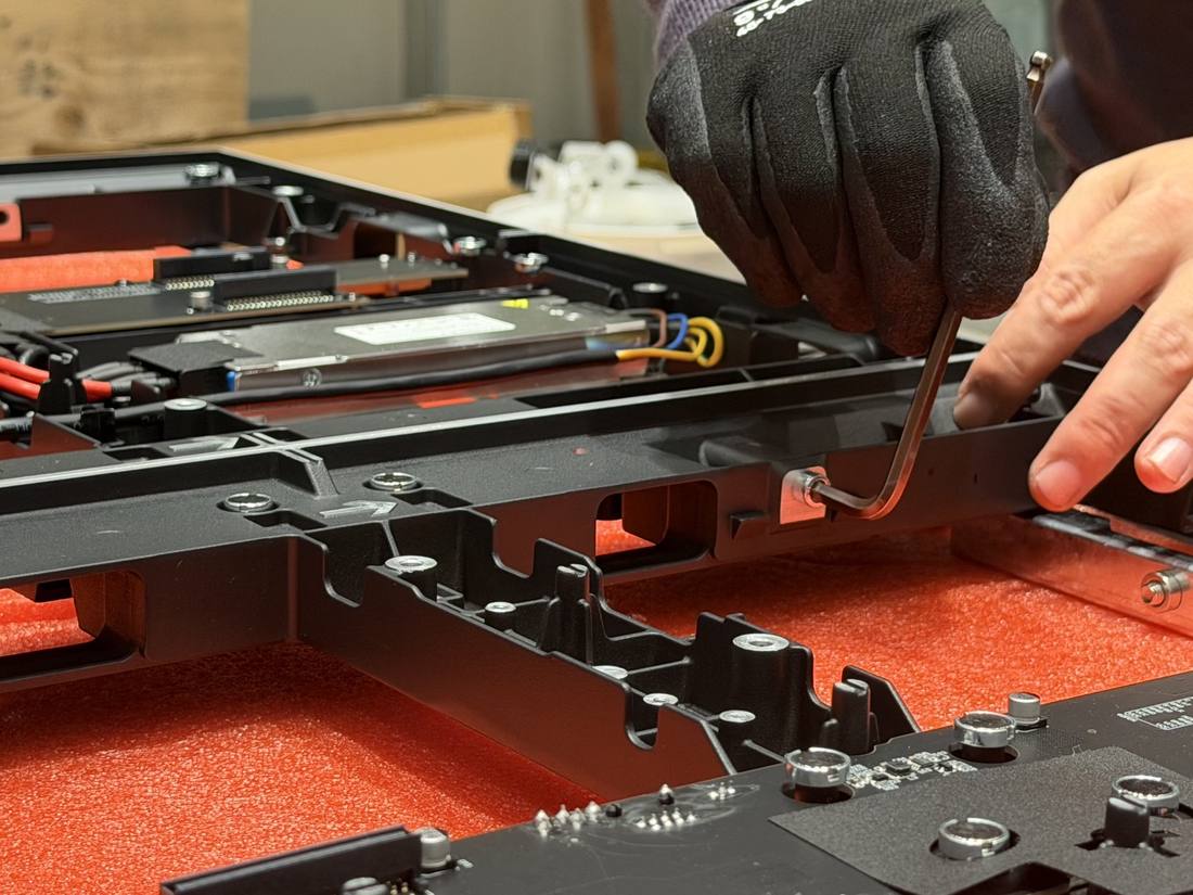 Technician assembling an LED video wall panel rear frame