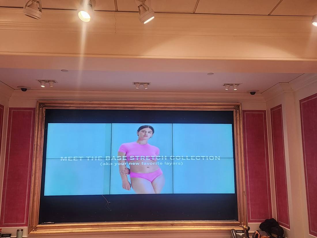 Gold-framed LED video wall running a fashion campaign
